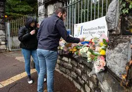 Alumnos y profesores depositan flores con mensajes de recuerdo a la profesora asesinada, en la entrada del Liceo Santo Tomás de Aquino de San Juan de Luz.