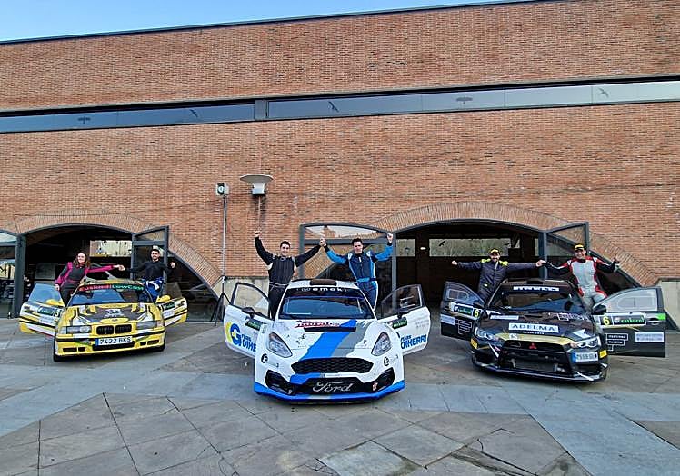 Los primeros tres clasificados celebrando su triunfo al pie de sus vehículos.