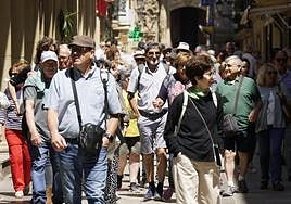 Un grupo de turistas recorre la calle Mayor, en la Parte Vieja donostiarra.