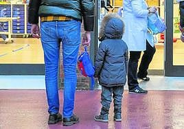 Escolares de infantil, acompañados de sus padres, en la entrada de un colegio.