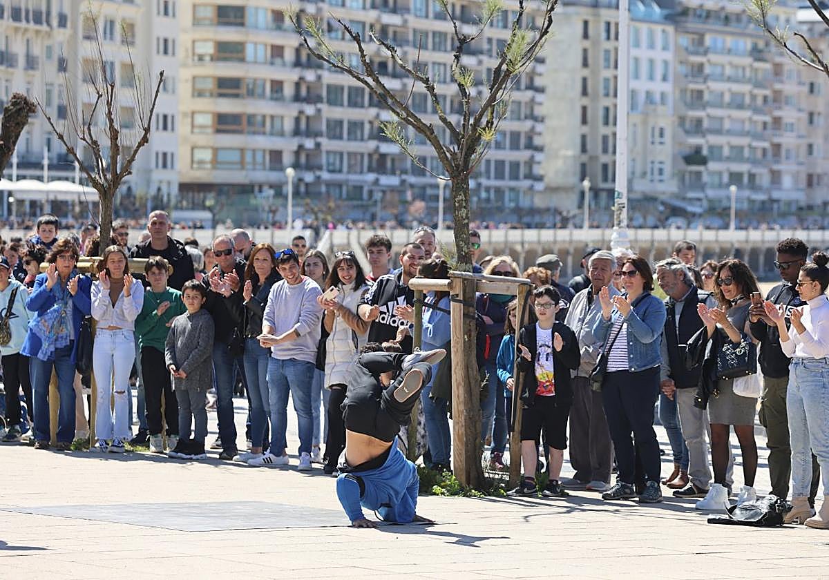 Turistas observan un espectáculo callejero ayer en Donostia.
