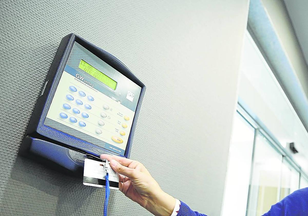 Una mujer ficha a la entrada del trabajo en una empresa.