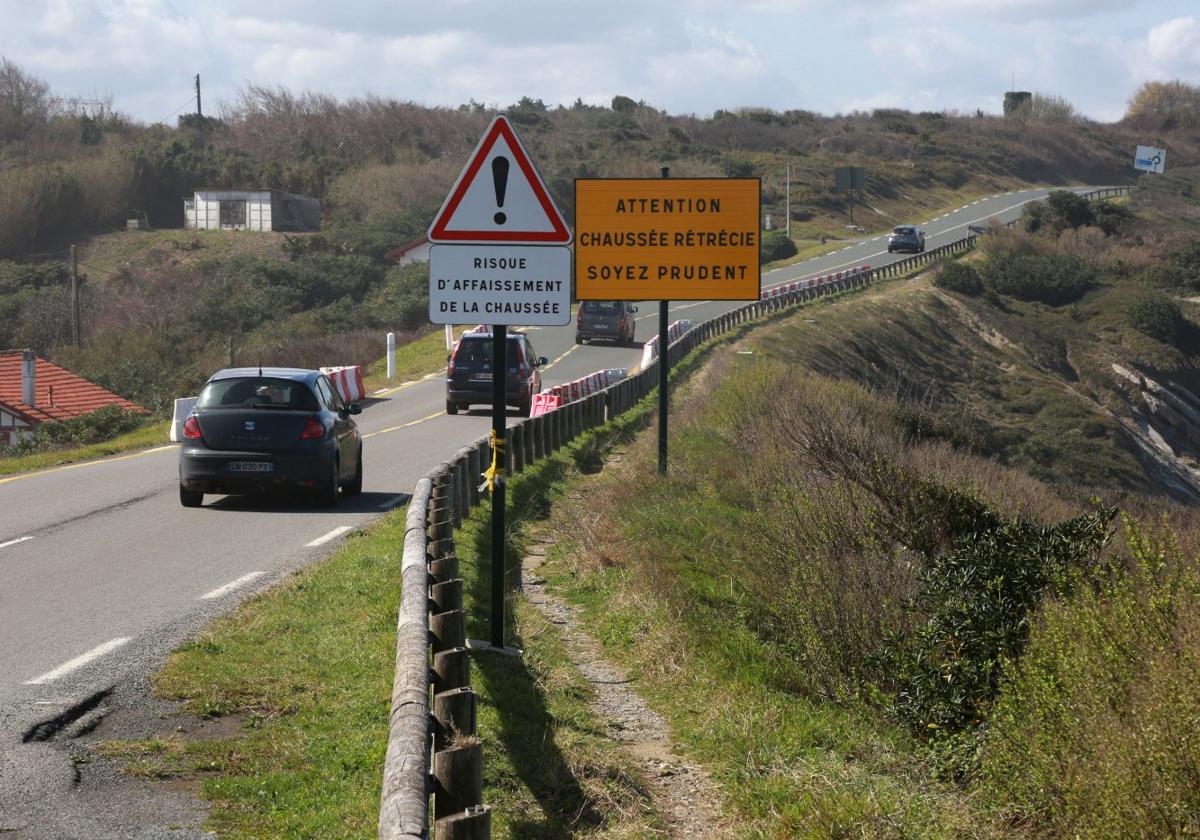 Tramo de la carretera de La Corniche en el que las señales alertan del riesgo de derrumbe de la calzada y del estrechamiento de la misma.