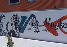 El mural está en la fachada de avda. Urdaneta,17, frente a la escuela de música.