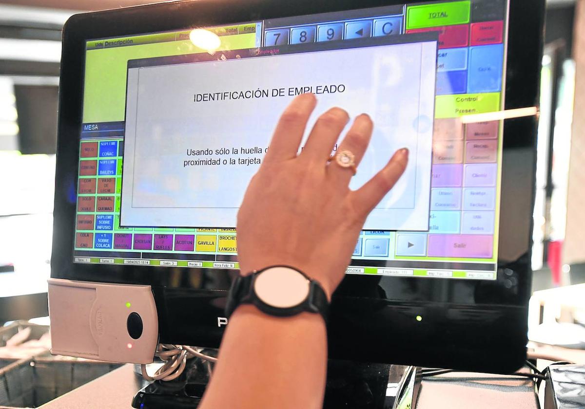 Una empleada del Campus de Ondarreta realiza el registro de su jornada laboral con una pulsera telemática.