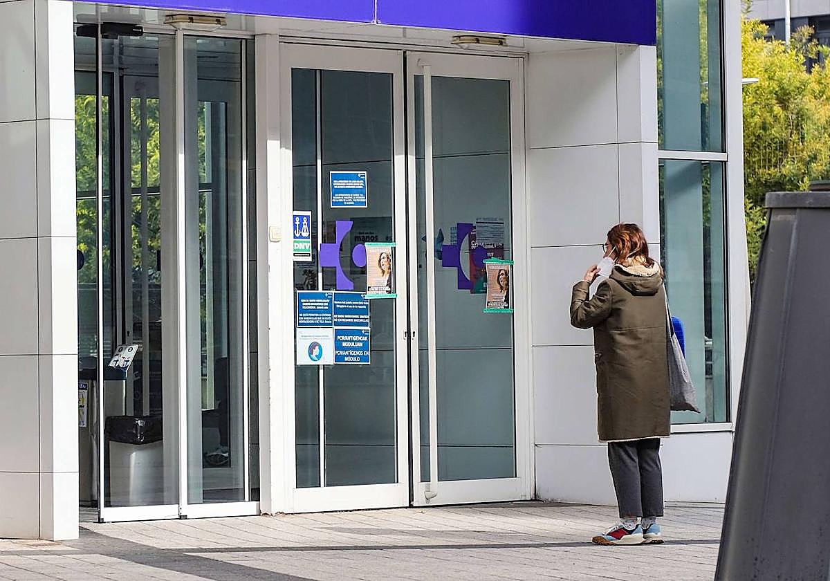 Una mujer se pone la mascarilla para acceder al centro de salud de Amara Berri, en Donostia.