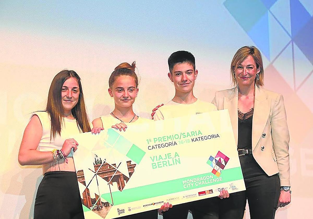 Los miembros de Gu Geu Sortzaile posan con el cheque y la alcaldesa de Arrasate.