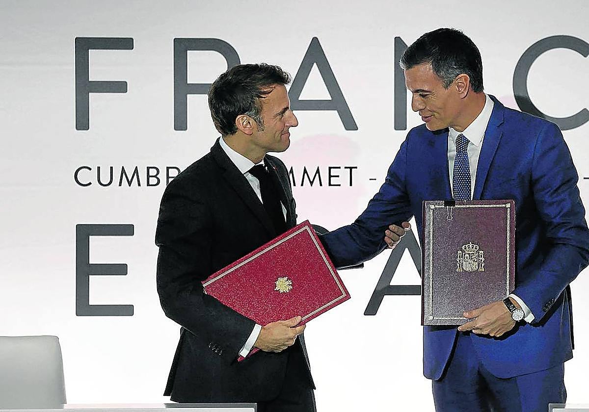 Emmanuel Macron y Pedro Sánchez se saludan e intercambian documentos tras la cumbre hispanofrancesa de Barcelona el pasado 19 de enero.