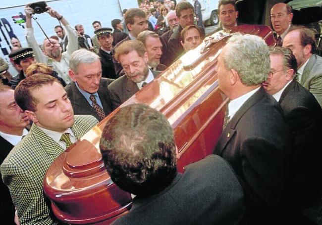 Compañeros de corporación de Caballero portan el féretro.