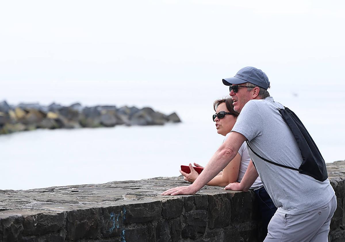 Dos personas contemplan el horizonte en Donostia.
