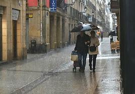 Una pareja por la Parte Vieja donostiarra en pleno aguacero