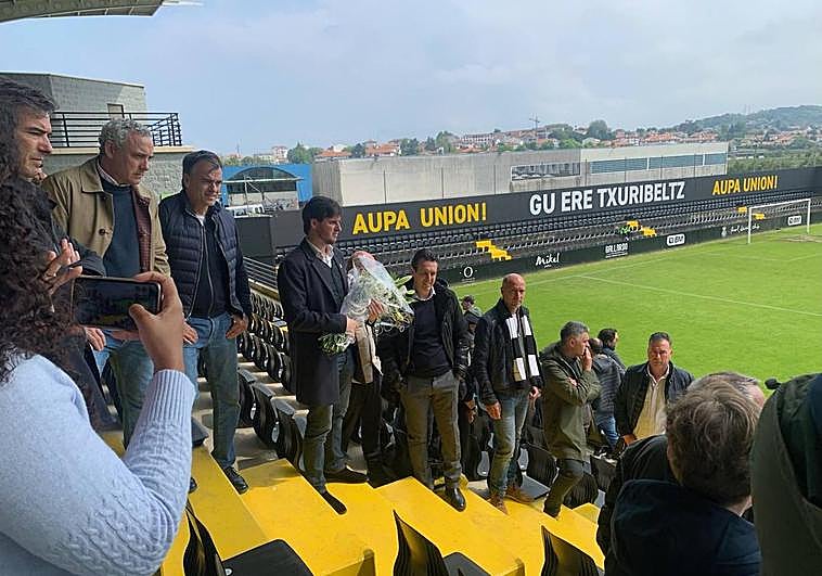 Igor Emery, presidente del Real Unión, porta un ramo de flores acompañado por su hermano Unai y el resto de aficionados del Real Unión que han acudido al homenaje previo.