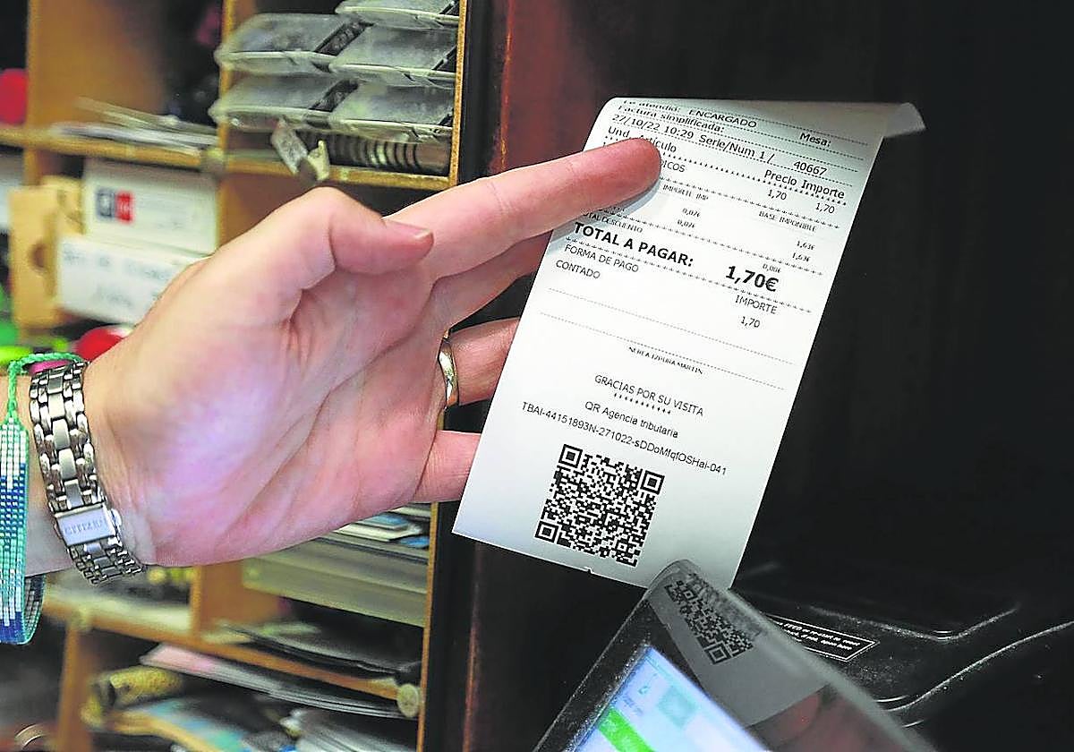 Una comerciante donostiarra emite una factura electrónica a un cliente.