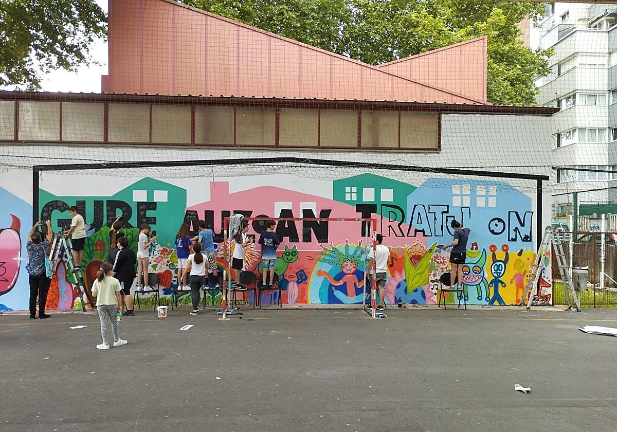 Los alumnos de la ikastola pintado el mural 'Gure auzoan Tratu On'.