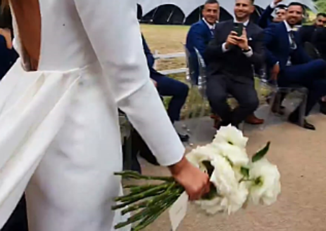 Imagen secundaria 1 - Detalle del ramo de la novia y de la espalda del vestido y su larguísimo faldón.