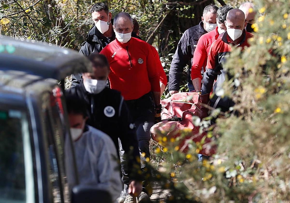 Agentes de la Ertzaintza trasladan el cadáver de la víctima.