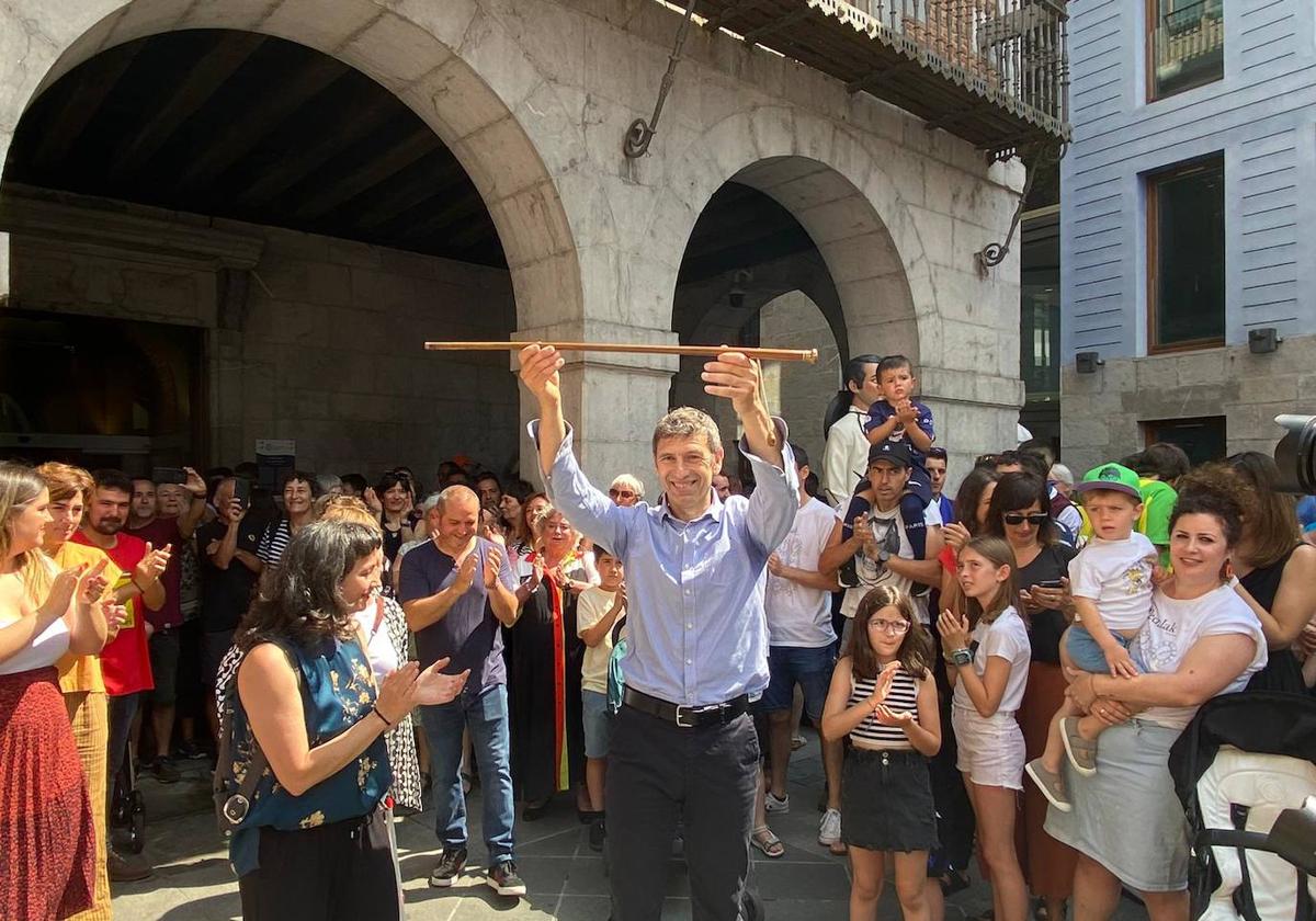 Andu Martínez de Rituerto levanta la makila de alcalde de Tolosa mientras es aplaudido en el exterior del ayuntamiento, donde EH Bildu gobernará con mayoría absoluta.