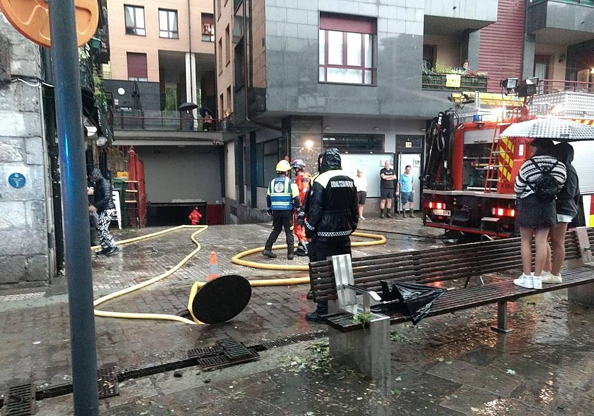 Bomberos achican agua a través de una alcantarilla, ayer tarde en Elgoibar.