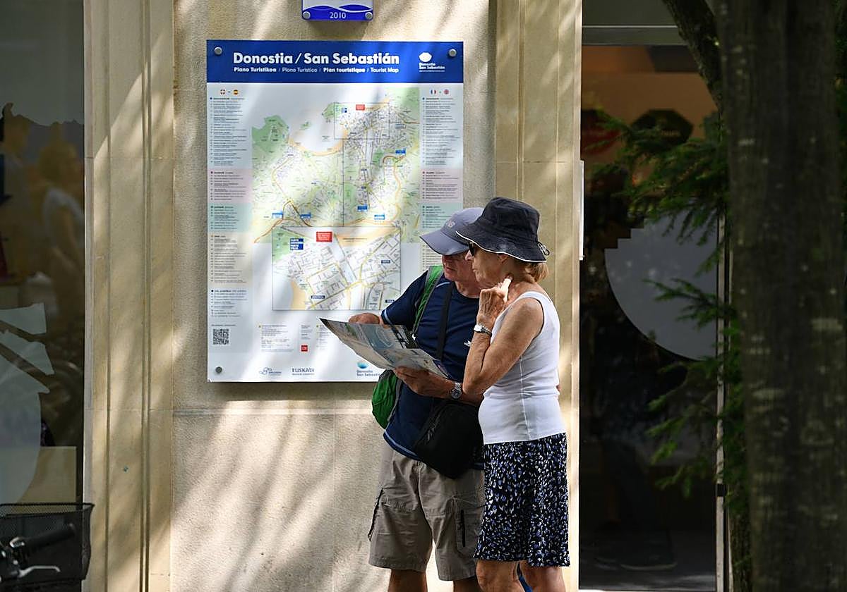 Una pareja de turistas pasea por el centro de San Sebastián.