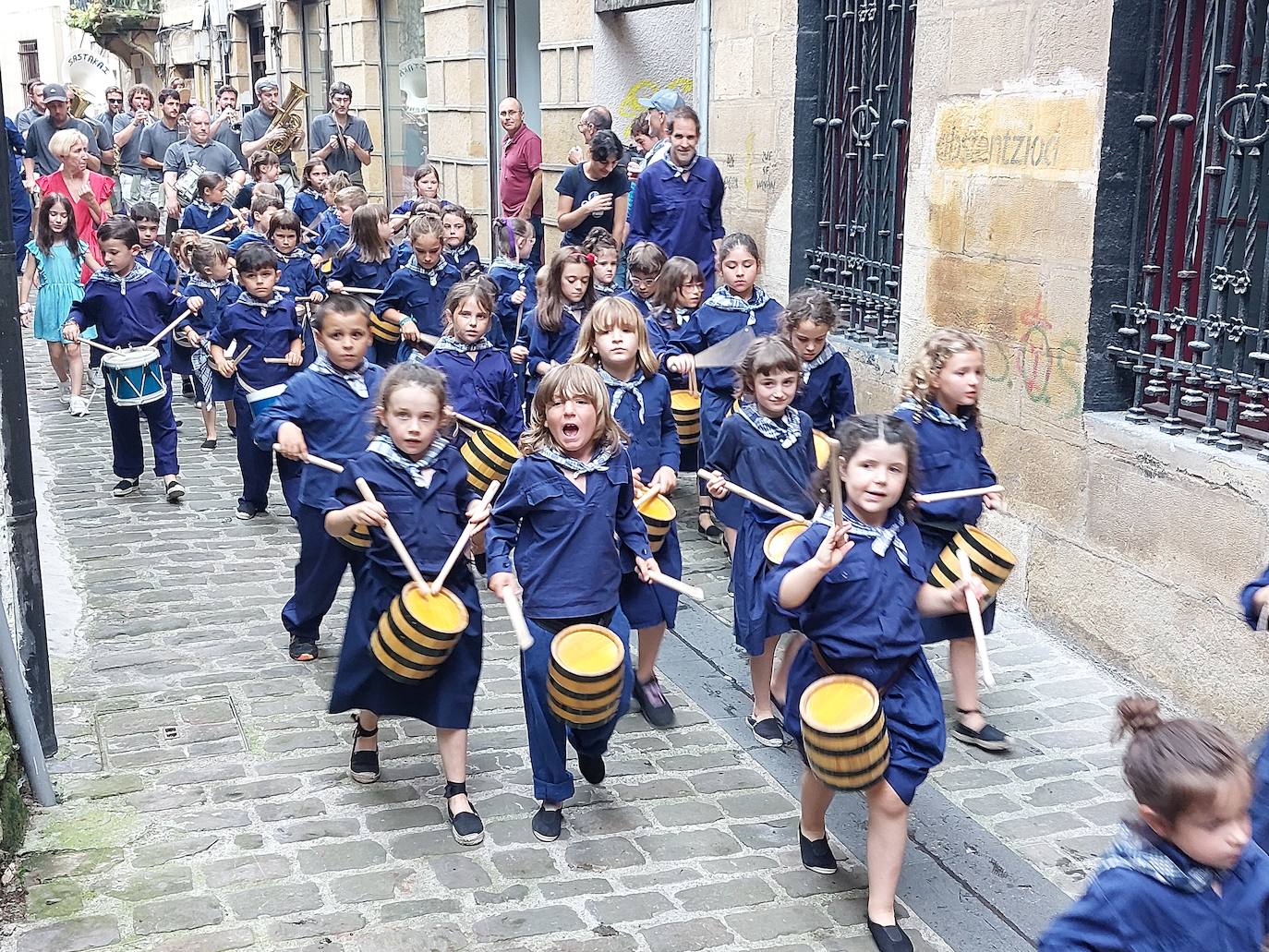 Tamborrada infantil de morado y calles multicolor
