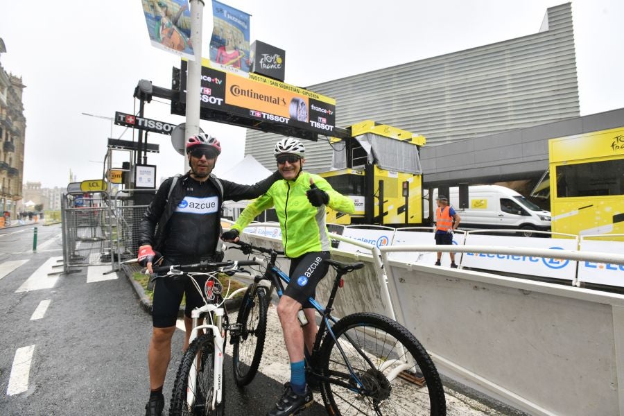 La lluvia no frena a la afición en la zona de meta en Donostia