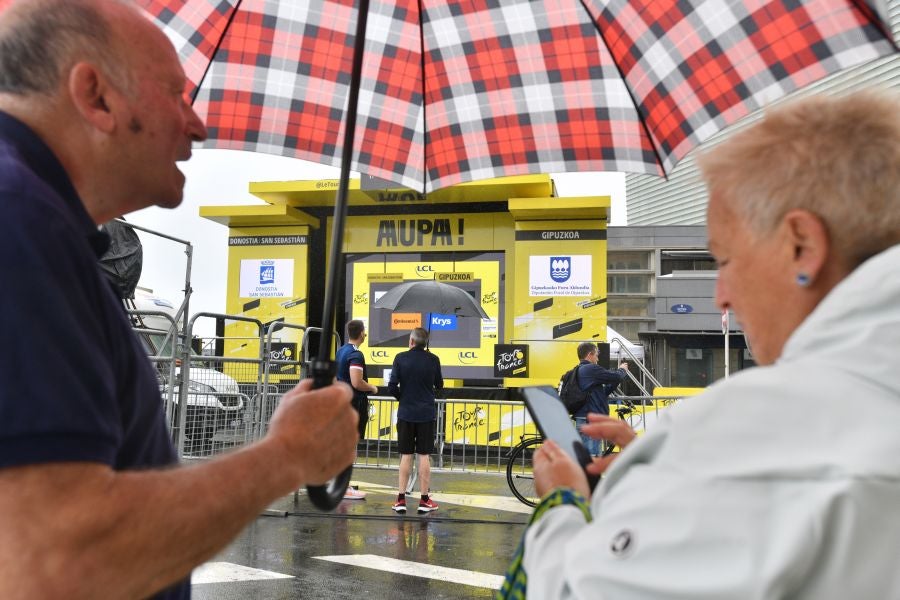 La lluvia no frena a la afición en la zona de meta en Donostia