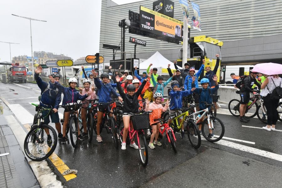 La lluvia no frena a la afición en la zona de meta en Donostia