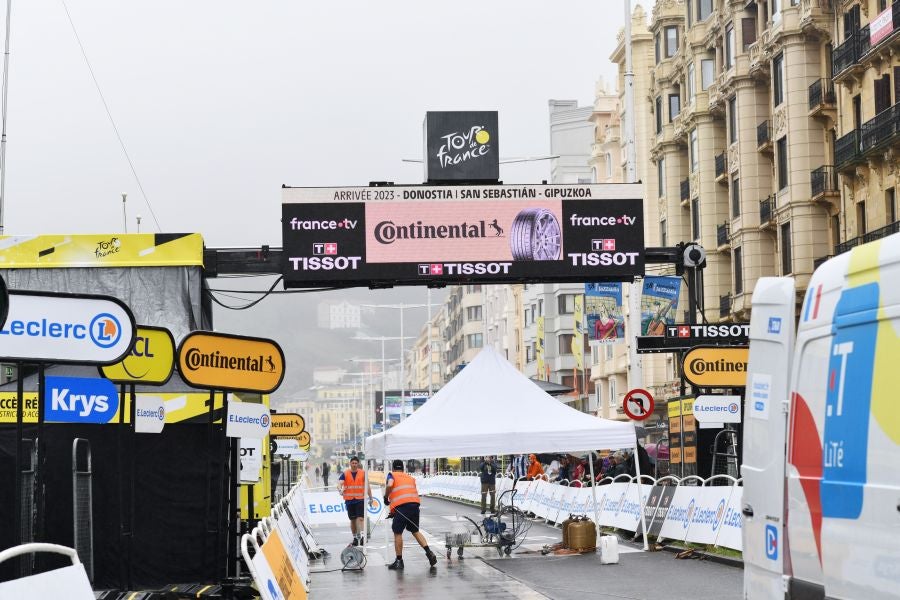 La lluvia no frena a la afición en la zona de meta en Donostia