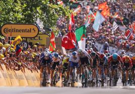 Sprint con suspense. Philipsen, de azul a la izquierda, se lanza a por la victoria en la recta de meta en Baiona tras superar a Van Aert, tapado por el ganador, en una acción junto a las vallas. El público también respondió en masa en la llegada del Tour a Iparralde.