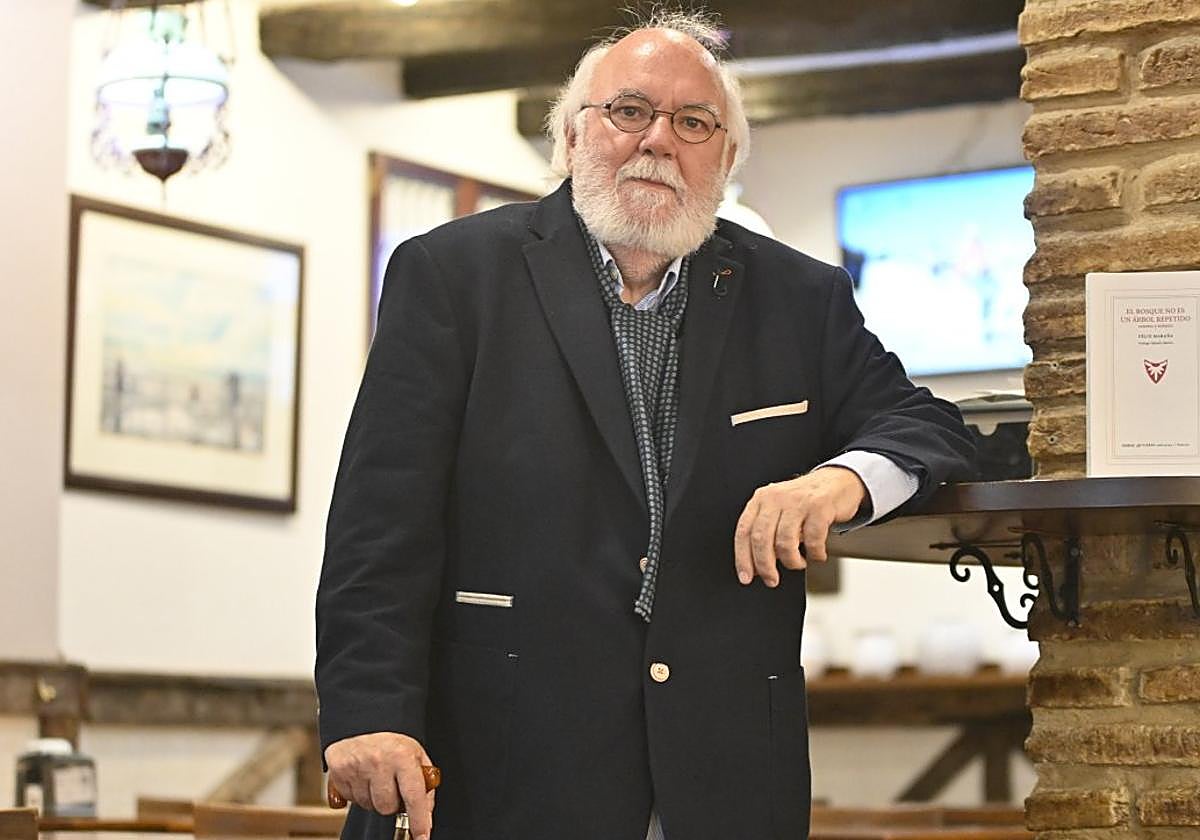 Félix Maraña, en un establecimiento hostelero del barrio de Gros, su 'territorio' en Donostia, junto a un ejemplar de su poemario.