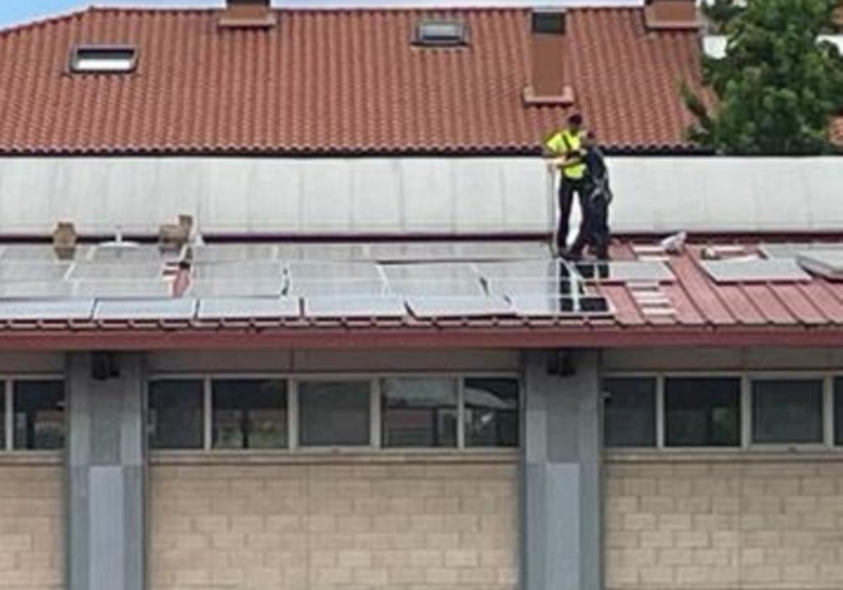 Un operario trabaja para instalar las placas en el tejado.