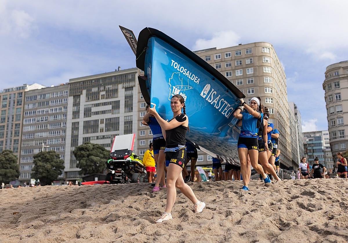 Las remeras de Tolosaldea llevan la trainera a la orilla de la playa para embarcar.