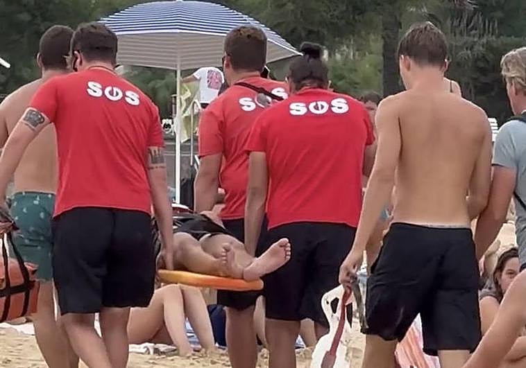 Socorristas de Ondarreta rescatan al joven golpeado por una ola.