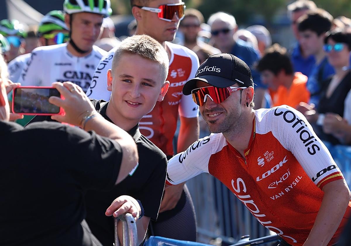 Ion Izagirre se fotografía con un chico en Donostia antes de la salida de la Clásica de San Sebastián.