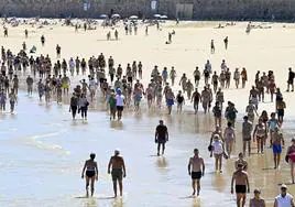 Numerosos bañistas pasean por la orilla en la playa de La Concha aprovechando el buen tiempo que lució ayer.