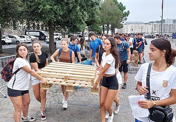 Un grupo de chicas se dirige al Muelle con el material necesario para preparar su embarcación.