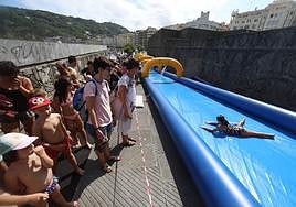 Decenas de niños esperan su turno para acceder al tobogán acuático.
