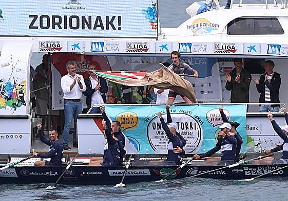Gorka Aranberri ondea la Ikurriña de Getaria ante la alegría de los remeros de Urdaibai.