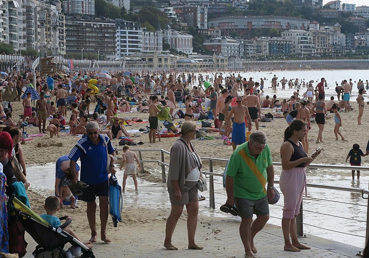 Varias personas abandonan ayer la playa de La Concha después de que la tarde se nublase.