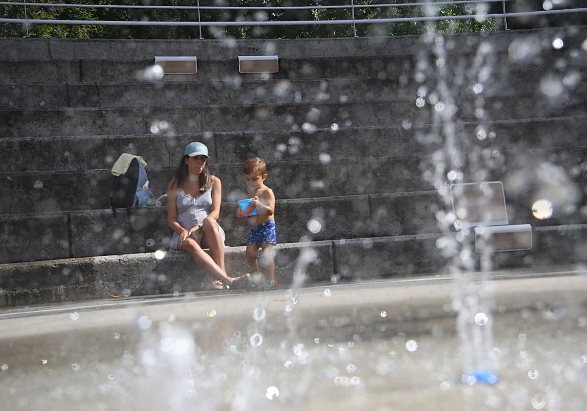 Un niño se refresca junto a su madre en una fuente de Beasain.