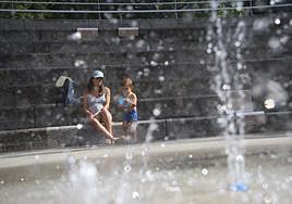 Un niño se refresca junto a su madre en una fuente de Beasain.