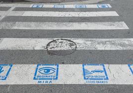Los pasos de cebra inclusivos tienen varios pictogramas azules, color que simboliza el autismo, sobre las habituales bandas blancas.