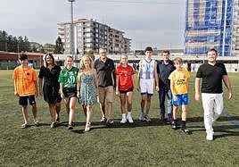 Cinco padres y madres posan junto a sus hijos, de diferentes equipos y deportes, en el campo San José Obrero de Irun.