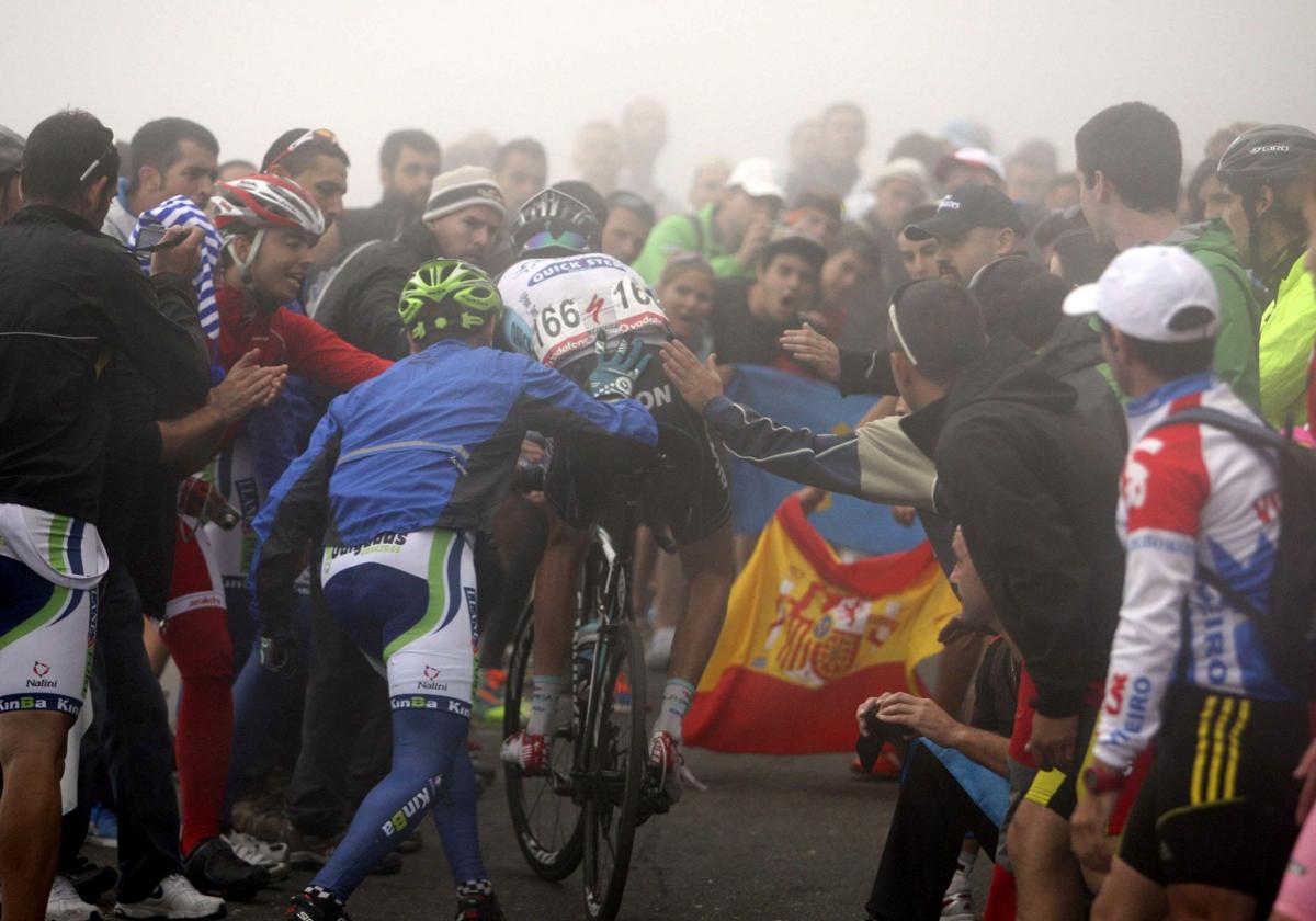 Aficionados ayudan a Pieter Serry, que corre la Vuelta 2023, en lo más duro del Angliru en una edición anterior.