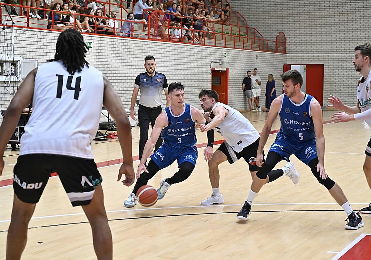 Alex barcello escapa de su defensor con la ayuda de Mike Carlson en el bloqueo, ayer en el polideportivo de Azkoitia.