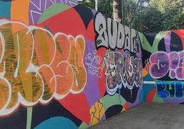 Grafitis pintados sobre el mural que decora el frontón del parque Aitzol.
