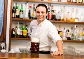 Un camarero sirve una cerveza a un cliente.