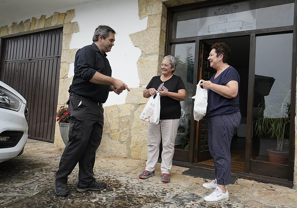 Lontxo Ormazabal entrega a Arantxa y Mariangeles Bidegain sus pedidos.