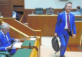 Jokin Bildarratz accede al pleno del Parlamento Vasco mientras el lehendakari Urkullu reisa unos papeles.