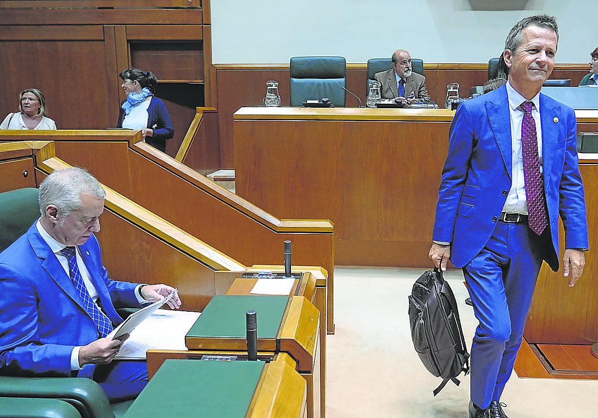 Jokin Bildarratz accede al pleno del Parlamento Vasco mientras el lehendakari Urkullu reisa unos papeles.